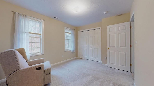 sitting room featuring baseboards, light carpet, and plenty of natural light