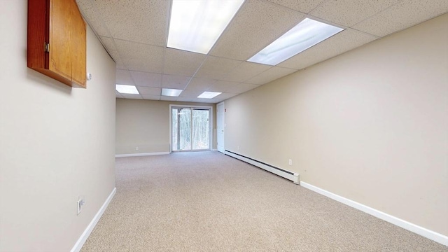 spare room with baseboards, a baseboard heating unit, a paneled ceiling, and light carpet