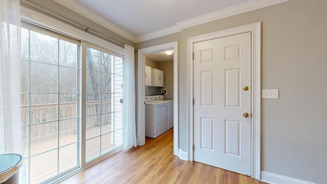 doorway to outside featuring light wood-style flooring, baseboards, crown molding, and washing machine and clothes dryer