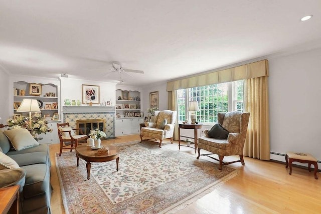 8 Viking Rock Rd, Yarmouth, MA 02664 - living area featuring crown molding, ceiling fan, built in shelves, a fireplace, and light wood finished floors