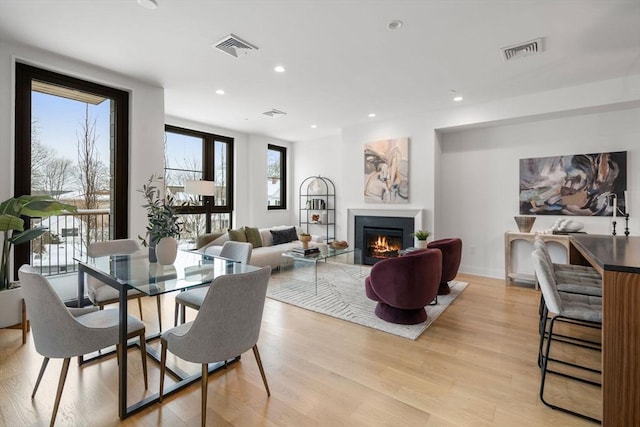 100 Linden St Unit 103, Wellesley, MA 02482 - dining area with a glass covered fireplace, light wood-type flooring, recessed lighting, and baseboards