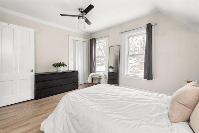 bedroom with light wood-type flooring, lofted ceiling, and a ceiling fan