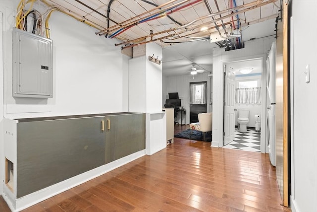 interior space with electric panel, ceiling fan, and wood-type flooring