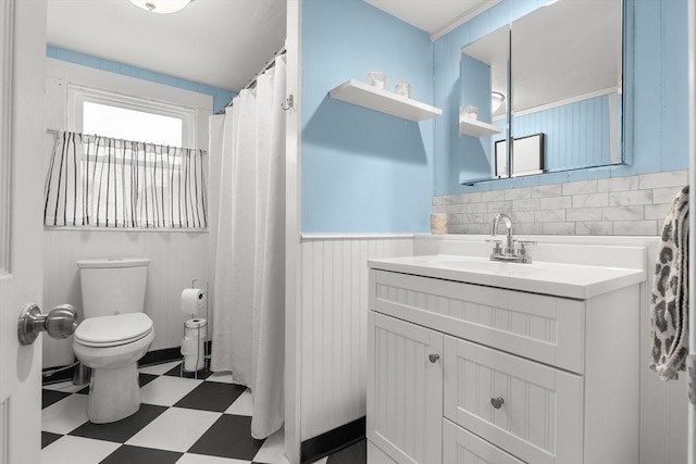 bathroom with tile patterned floors, a wainscoted wall, toilet, and vanity