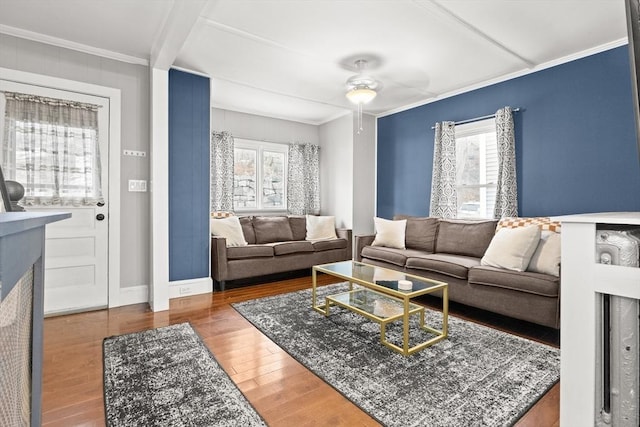 living area with a wealth of natural light, crown molding, and wood finished floors