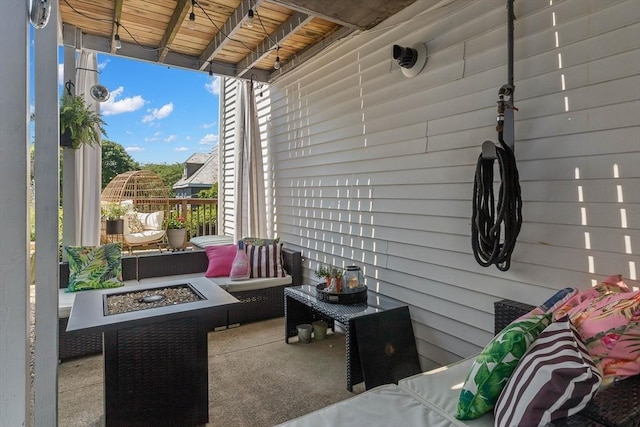 view of patio with an outdoor living space with a fire pit