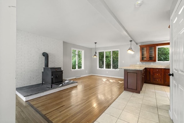731-R Grove St, Norwell, MA 02061 - kitchen with a wood stove, glass insert cabinets, light wood-type flooring, hanging light fixtures, and beamed ceiling
