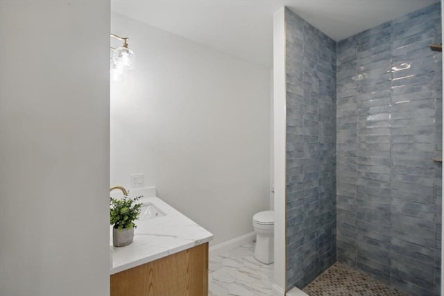 full bath with vanity, baseboards, tiled shower, toilet, and marble finish floor