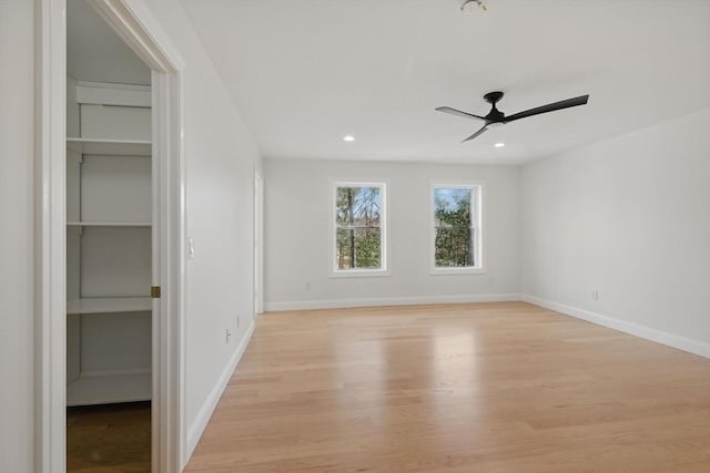 unfurnished bedroom featuring a spacious closet, recessed lighting, baseboards, and light wood-type flooring