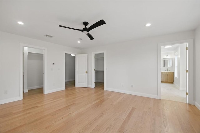 unfurnished bedroom with a walk in closet, recessed lighting, visible vents, and light wood-type flooring