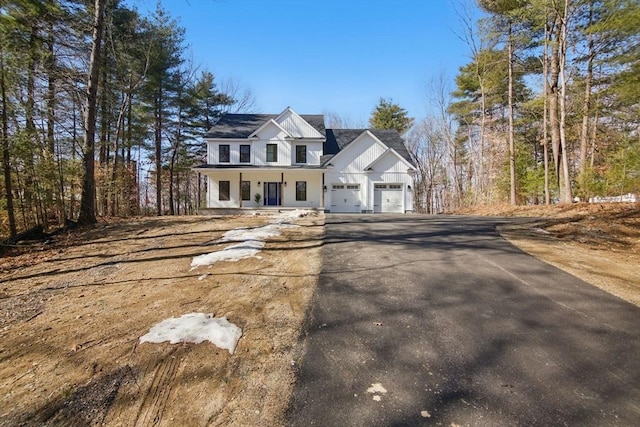 view of front of property with a garage, a porch, and driveway