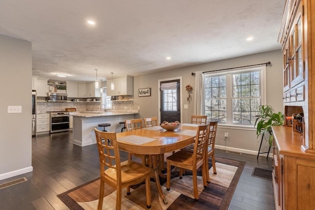 dining space with recessed lighting, baseboards, and dark wood-style floors