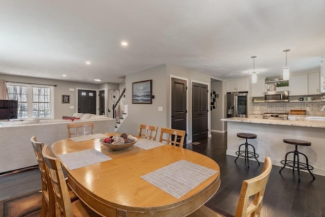 dining space featuring stairway, recessed lighting, and dark wood-style flooring