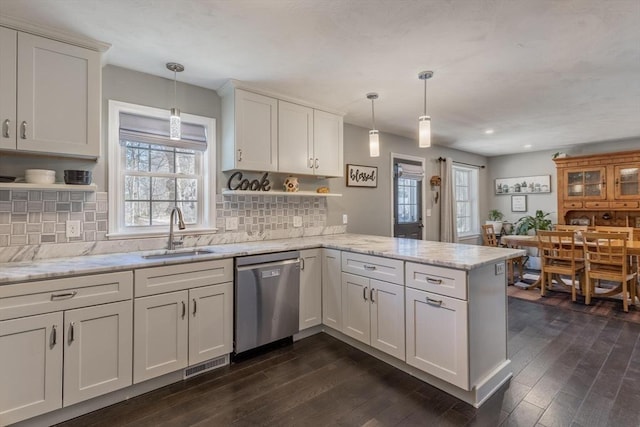 kitchen with visible vents, dark wood finished floors, dishwasher, a peninsula, and a sink