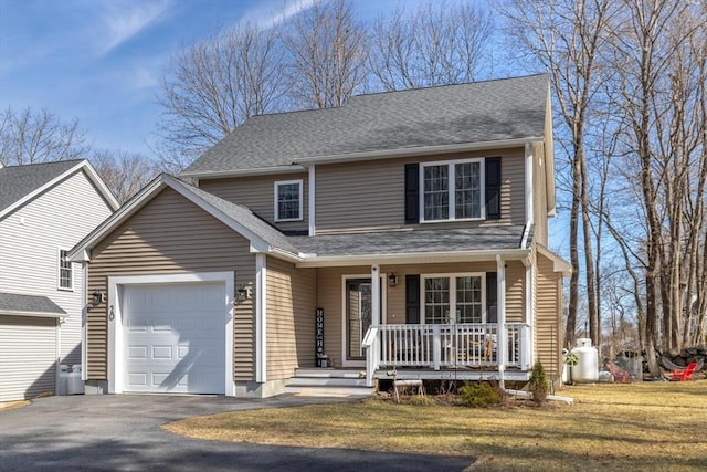 traditional-style house featuring aphalt driveway, covered porch, a front yard, a shingled roof, and a garage