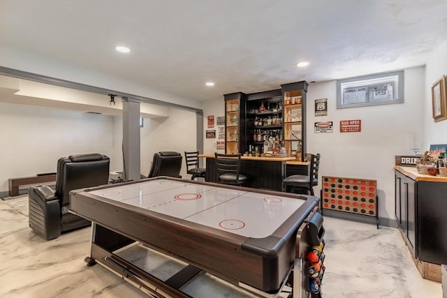 recreation room with recessed lighting, baseboards, and a dry bar