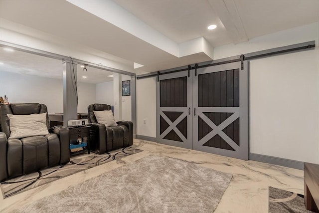 cinema room featuring marble finish floor, baseboards, and a barn door