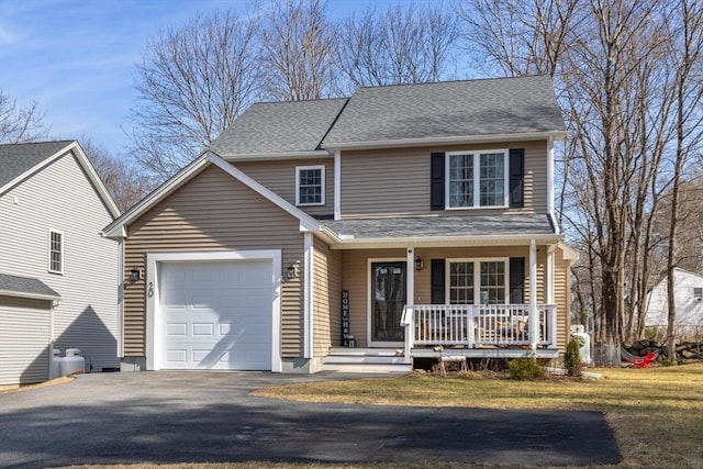 traditional home with driveway, a porch, an attached garage, and a shingled roof