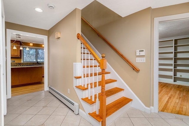 stairs with tile patterned flooring and baseboard heating