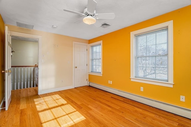 unfurnished room with ceiling fan, light hardwood / wood-style flooring, and a baseboard radiator