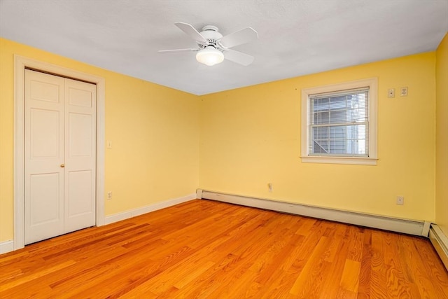 unfurnished bedroom featuring a closet, ceiling fan, light hardwood / wood-style flooring, and a baseboard radiator