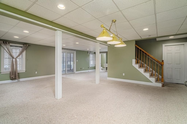 basement featuring a paneled ceiling and carpet floors