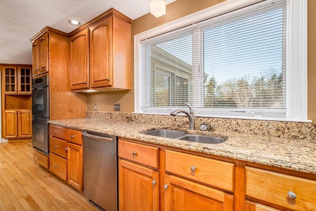 kitchen with dishwasher, plenty of natural light, double oven, and sink