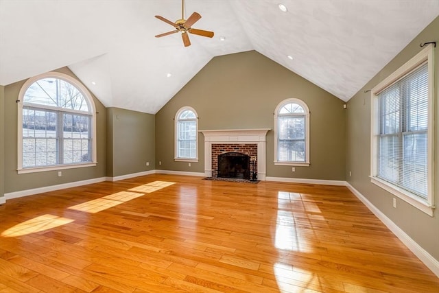 unfurnished living room featuring ceiling fan, a fireplace, lofted ceiling, and light wood-type flooring