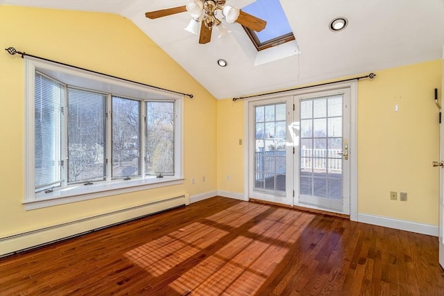 unfurnished room featuring ceiling fan, vaulted ceiling with skylight, wood-type flooring, and a baseboard heating unit