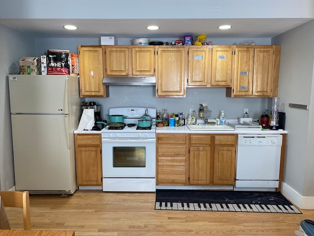 kitchen featuring white appliances, sink, and light hardwood / wood-style floors