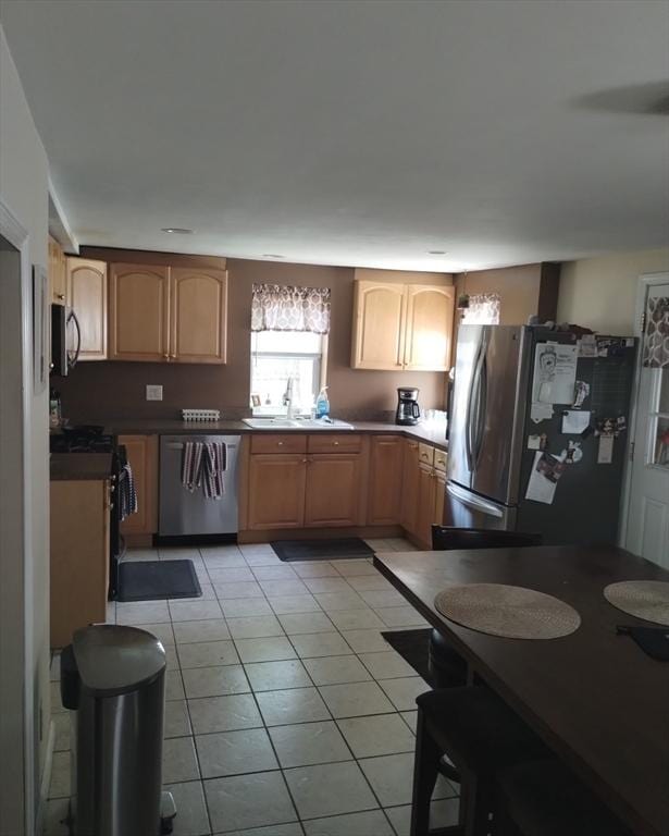 7 Pontos Ave, Burlington, MA 01803 - kitchen with stainless steel appliances, a sink, light tile patterned floors, and dark countertops