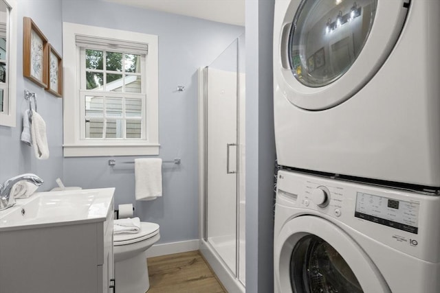 laundry room featuring sink, stacked washing maching and dryer, and light wood-type flooring