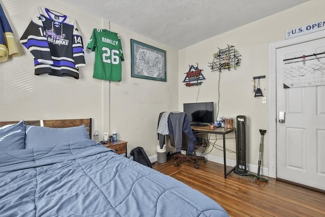 bedroom with wood finished floors and baseboards