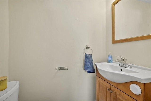 half bathroom with vanity and toilet