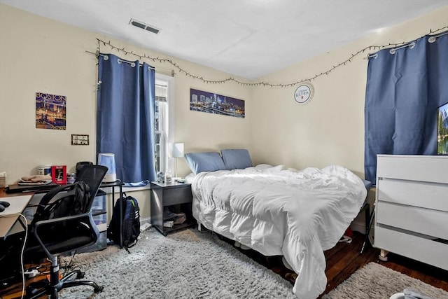 bedroom featuring wood finished floors and visible vents