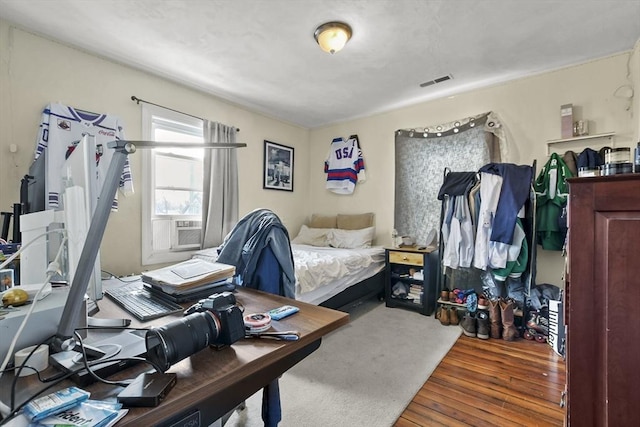 bedroom featuring visible vents and wood finished floors