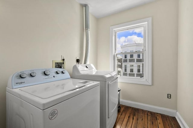 clothes washing area with laundry area, baseboards, dark wood finished floors, and washer and dryer