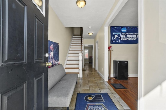 entrance foyer with stairway, tile patterned flooring, and baseboards