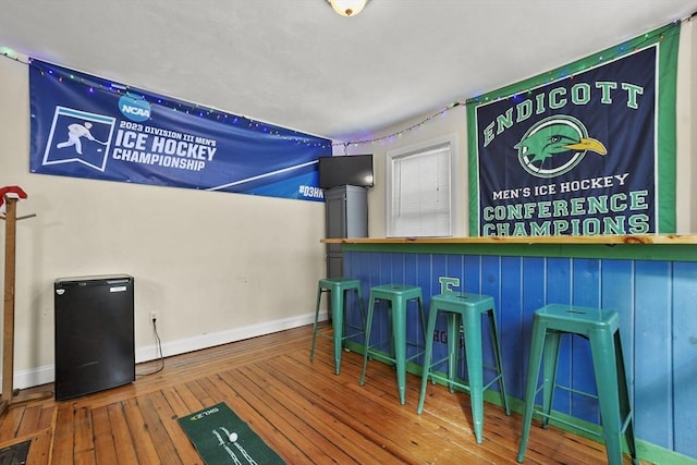 bar featuring baseboards and hardwood / wood-style floors