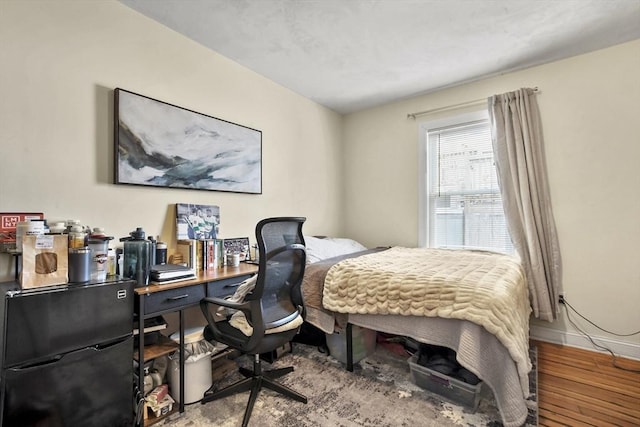 bedroom with baseboards and wood finished floors