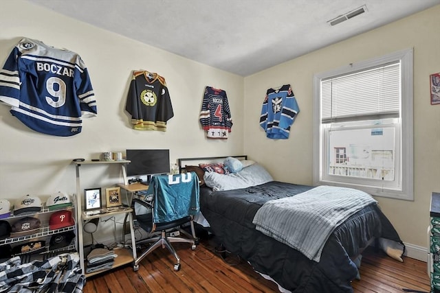 bedroom featuring dark wood-style flooring, visible vents, and baseboards