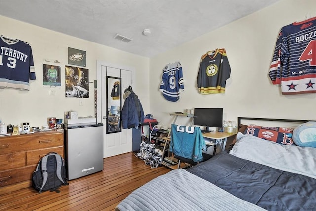 bedroom featuring wood-type flooring and visible vents