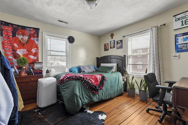 bedroom featuring wood-type flooring and visible vents