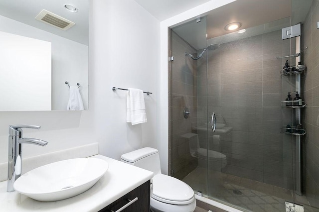 full bathroom featuring visible vents, a shower stall, toilet, and vanity