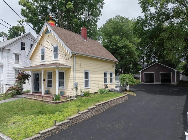 67 Pine St, Milford, MA 01757 - view of front facade with a chimney, covered porch, a detached garage, an outdoor structure, and a front yard