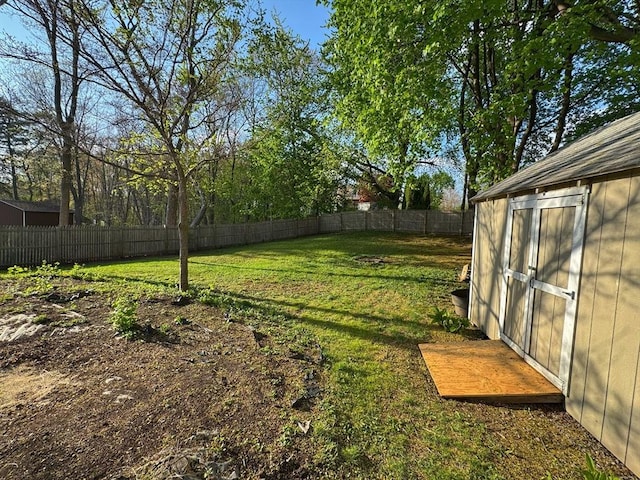 view of yard with an outbuilding, a storage shed, and a fenced backyard