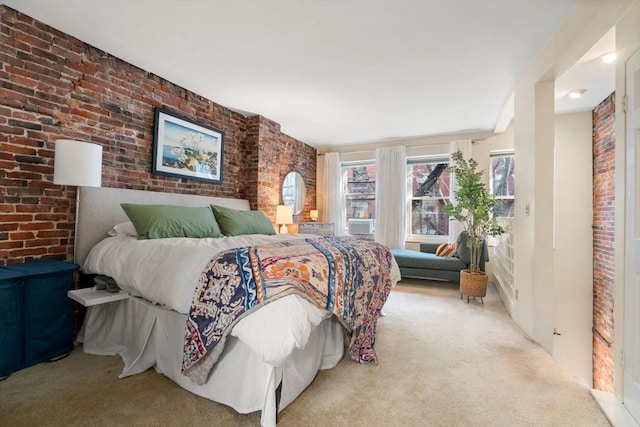 bedroom featuring carpet floors and brick wall