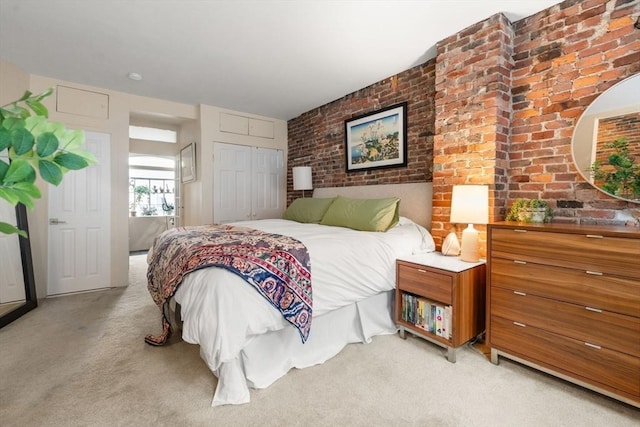 bedroom with light carpet and brick wall