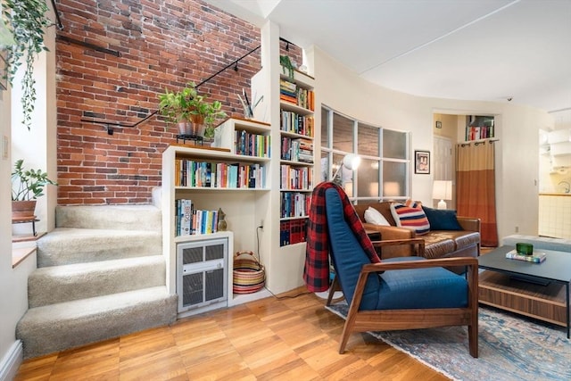 sitting room featuring brick wall and stairs