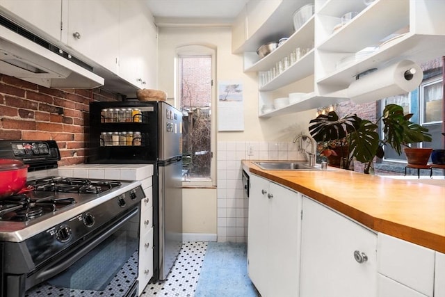 kitchen with white cabinets, range with gas cooktop, under cabinet range hood, wooden counters, and a sink